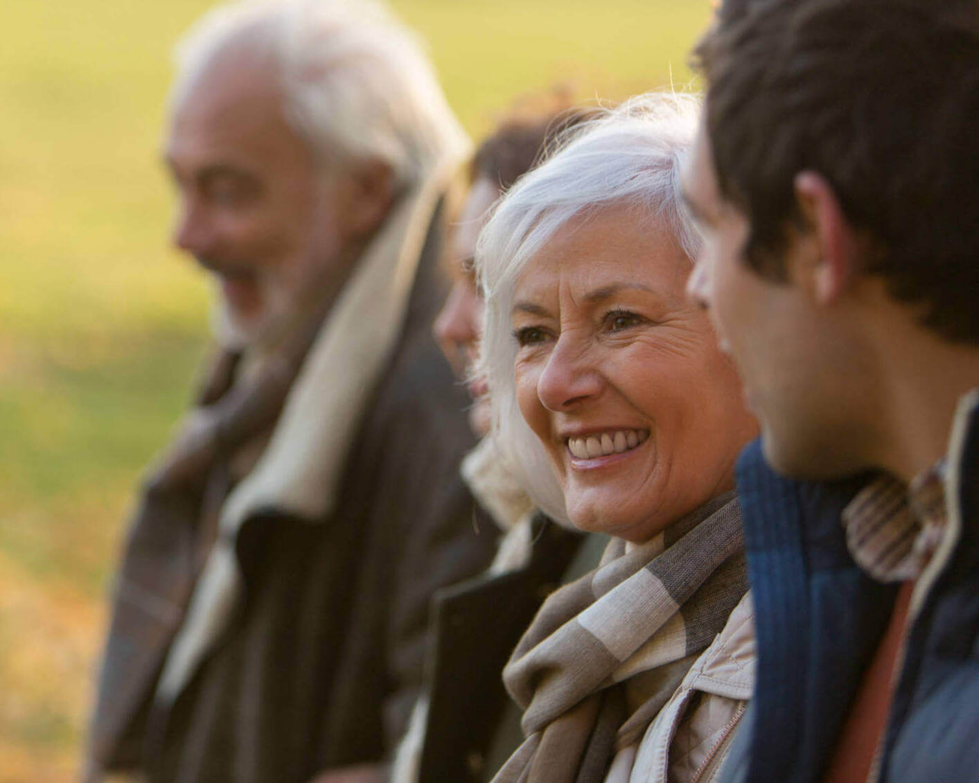 Happy Senior Woman In Autumn Park With Family